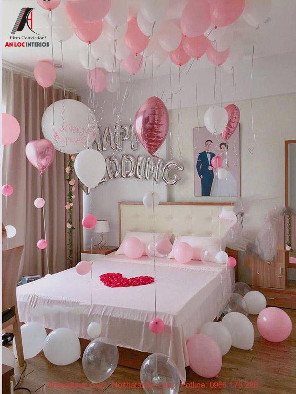 Mẫu 21 - Trang trí phòng tân hôn nhỏ với bóng bay, hoa hồng và ảnh cưới trên đầu giường